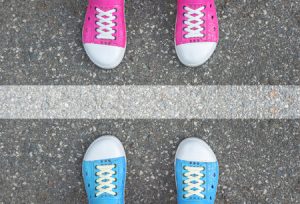 48063000 - blue shoes and pink shoes standing on asphalt concrete floor and white line between them